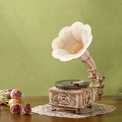 Decorative gramophone on a wooden surface with a green background